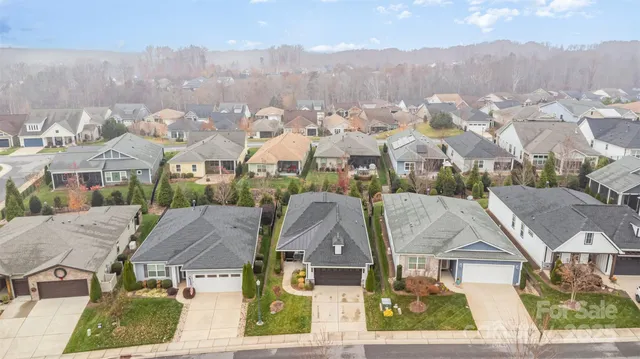 an aerial view of residential houses with outdoor space and trees