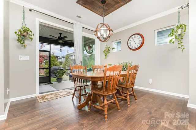 a view of a dining room with furniture a chandelier and wooden floor