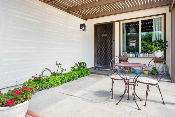 a view of a patio with table and chairs and potted plants