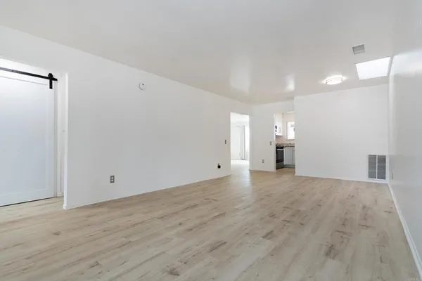 a view of empty room with wooden floor
