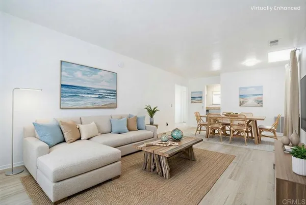 a living room with furniture potted plant and kitchen view