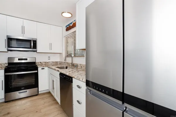 a kitchen with stainless steel appliances a stove microwave and sink