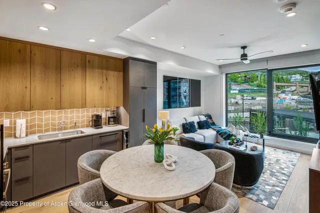 a dining room with furniture and large windows