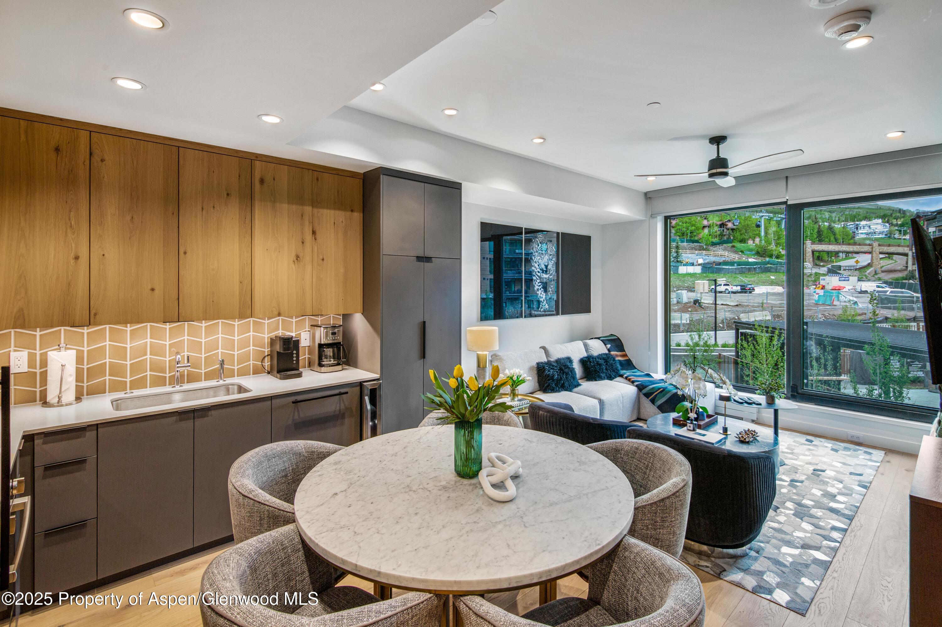 a dining room with furniture and large windows