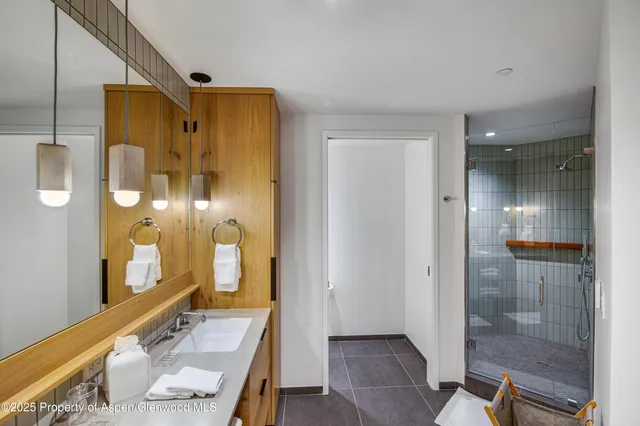 a bathroom with a glass shower door and a mirror