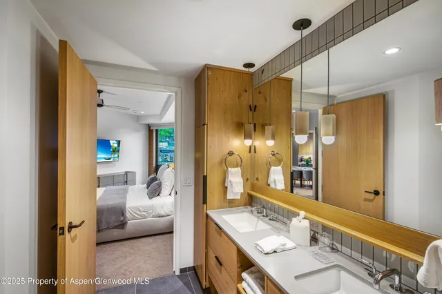 a en suite bathroom with a double vanity sink a mirror and a shower