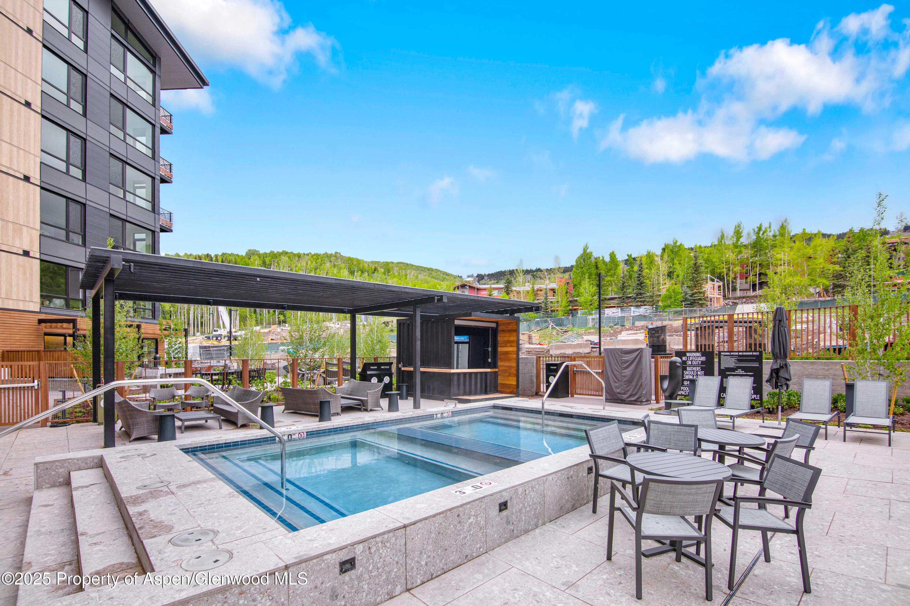 119 Wood Road, Unit 207 Snowmass Village, CO 81615 - Photo 23 of 26 a view of a patio with swimming pool table and chairs