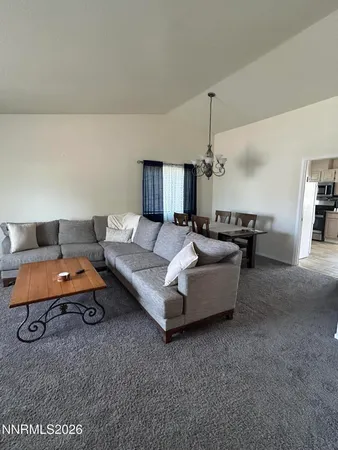 a living room with furniture and a chandelier