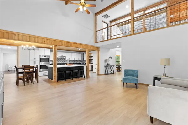 a living room with furniture a flat screen tv and kitchen view