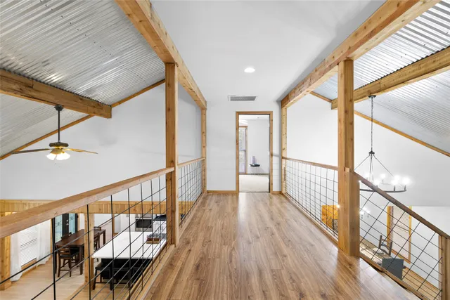 a view of hallway with wooden floor and furniture