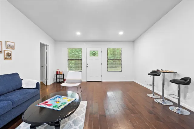 a living room with furniture and a wooden floor