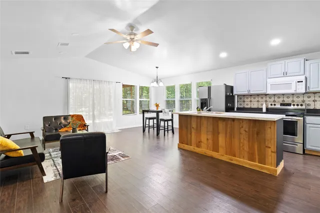 a living room with furniture and kitchen view