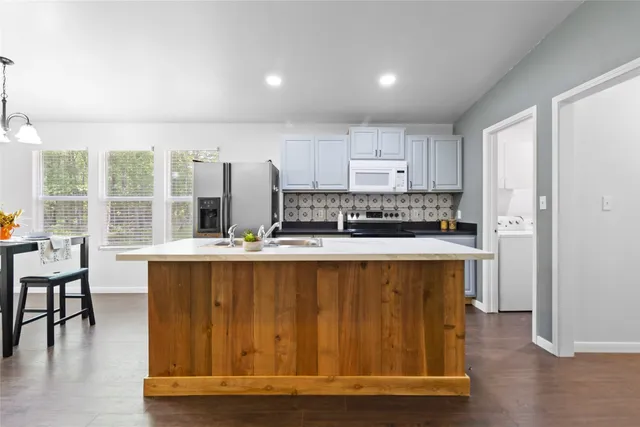 a kitchen with stainless steel appliances granite countertop a stove and a refrigerator