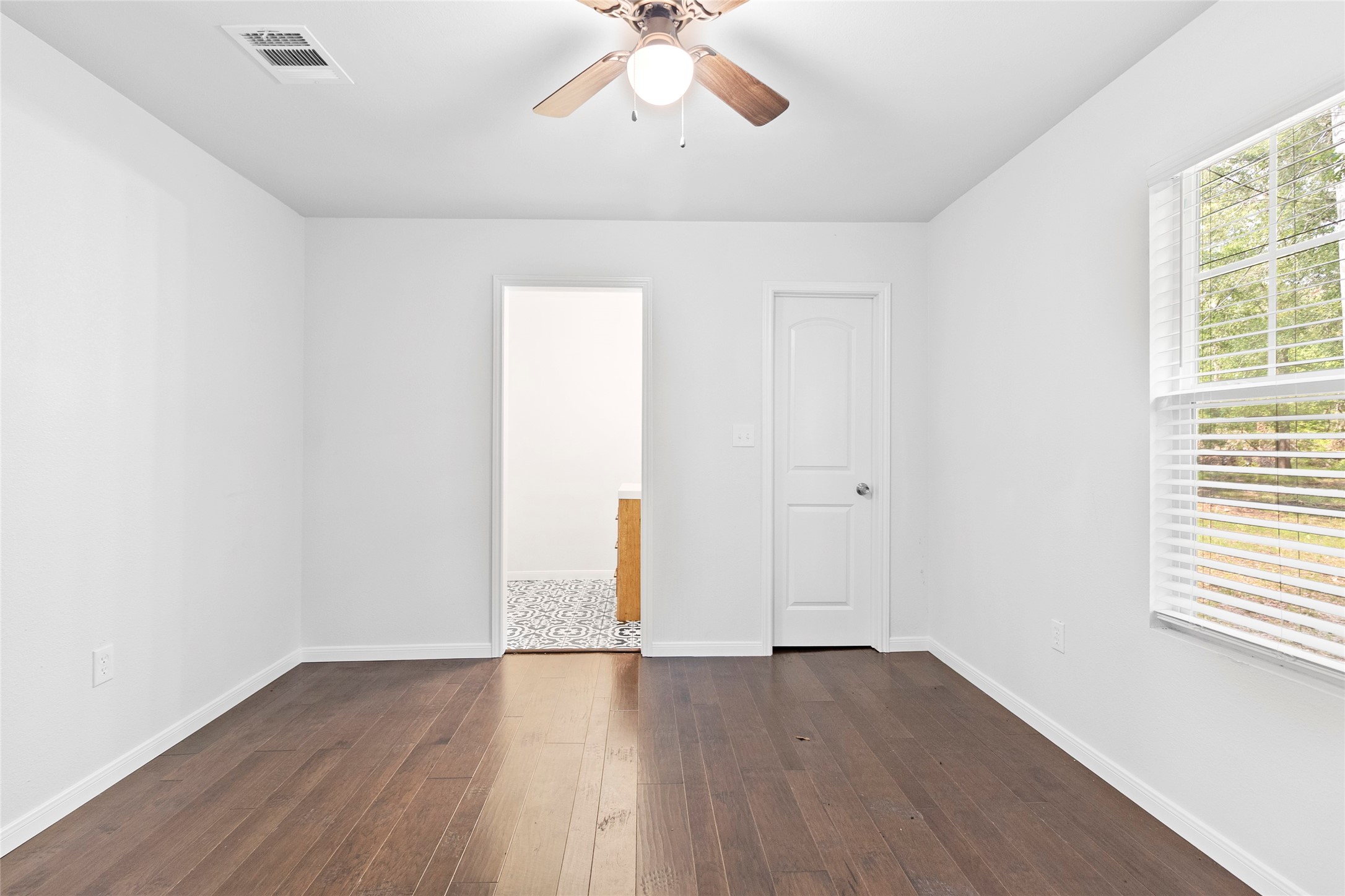 553 County Road 370 Splendora, TX 77372 - Photo 29 of 41 an empty room with wooden floor chandelier fan and windows