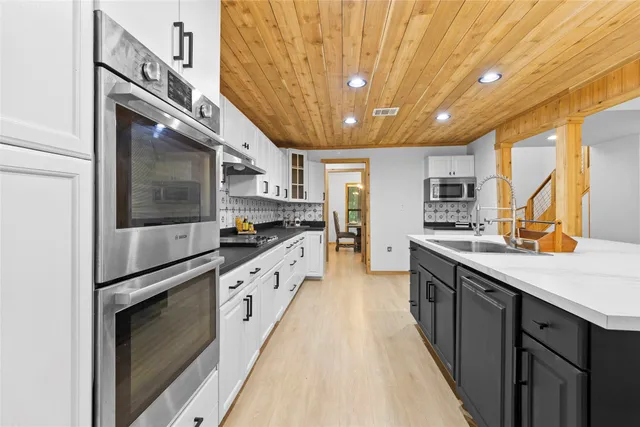 a kitchen with stainless steel appliances granite countertop a sink a stove and a refrigerator