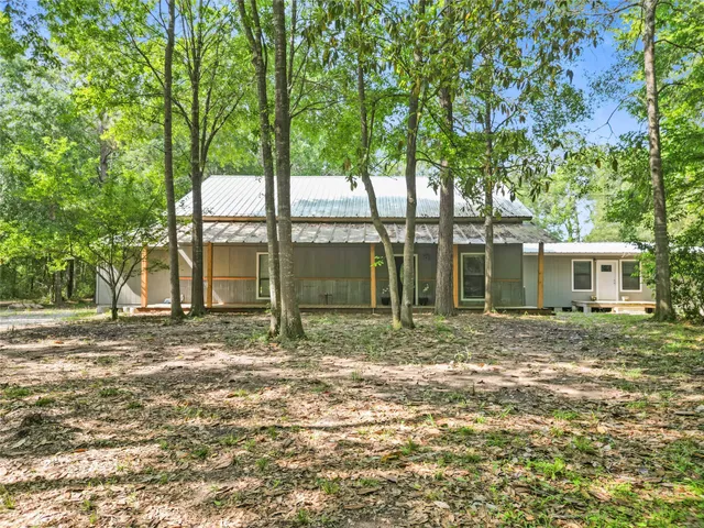 a view of a house with backyard and a tree