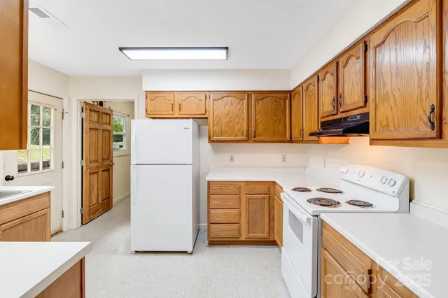 a kitchen with a refrigerator a stove a sink and cabinets