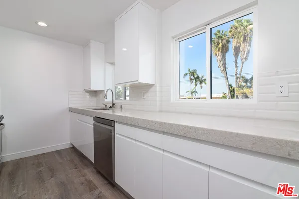 a bathroom with a granite countertop sink and a window