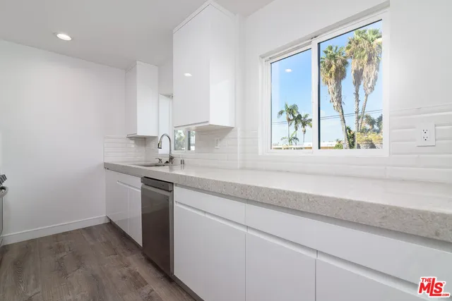 a bathroom with a granite countertop sink and a window