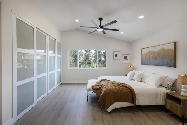 a bedroom with a large bed and a chandelier