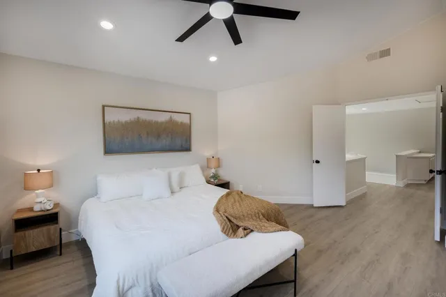 a bedroom with a bed and wooden floor