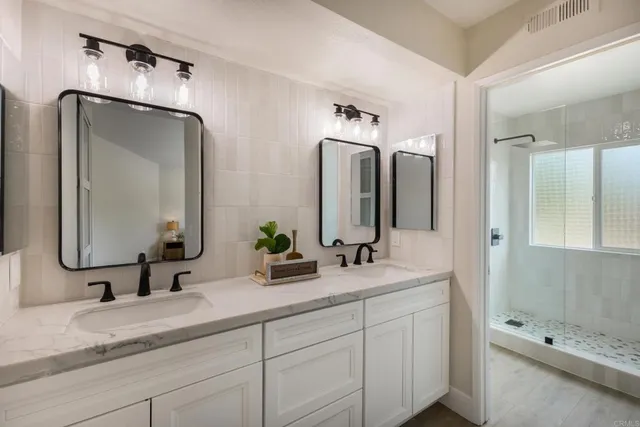 a bathroom with double vanity sinks and a mirror