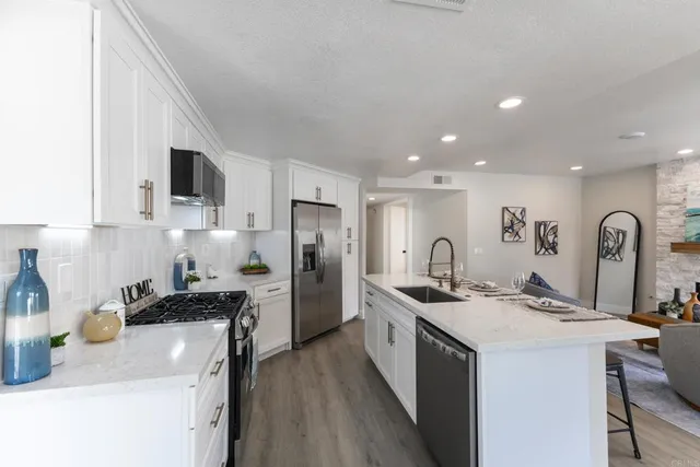 a kitchen with stainless steel appliances granite countertop a sink stove and refrigerator