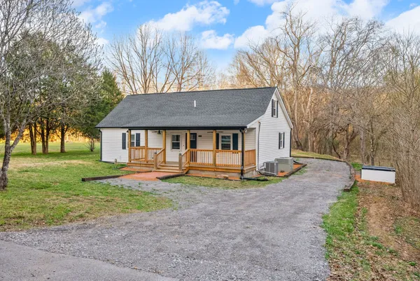 a view of a house with backyard and trees
