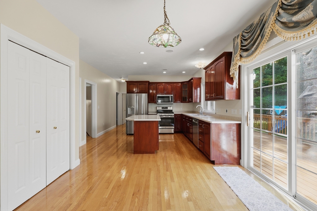 61 Indian Head Road Framingham, MA 01701 - Photo 12 of 42 a open kitchen with stainless steel appliances granite countertop a sink a stove a refrigerator cabinets and living room view