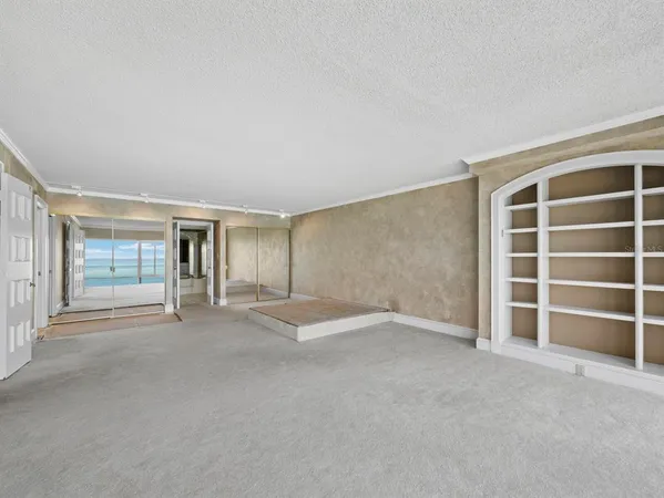 a view of an empty room with closet and a window
