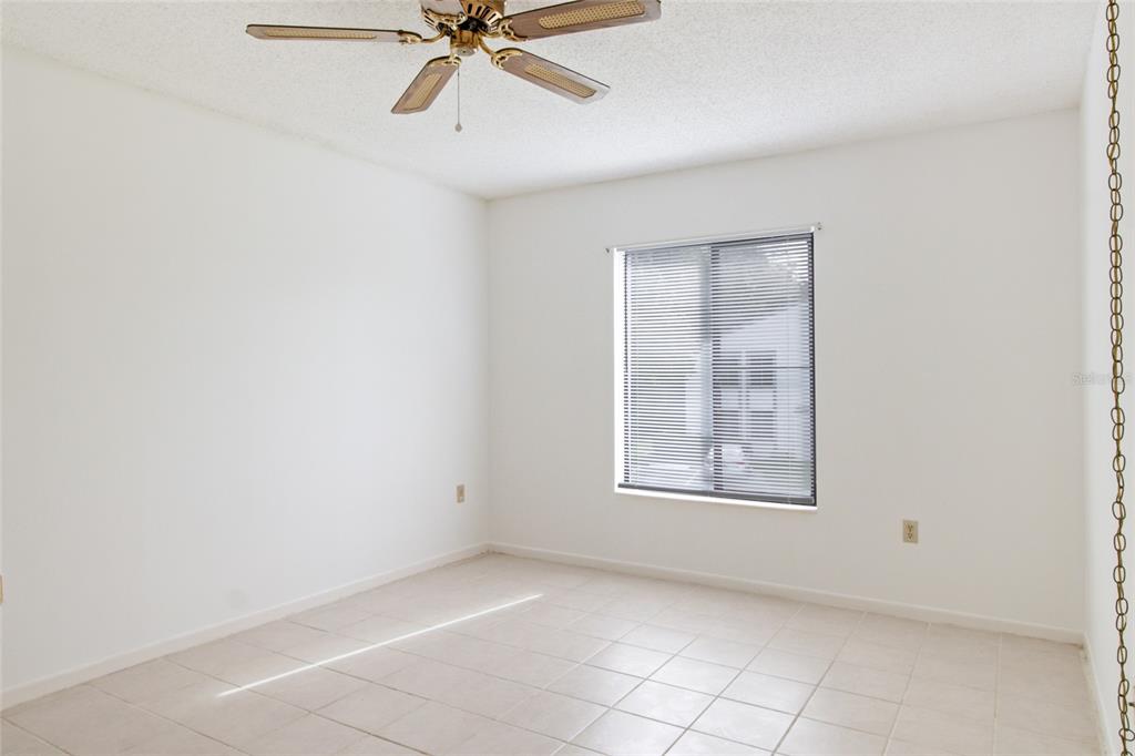 1308 Pine Ridge Circle East, Unit H2 Tarpon Springs, FL 34688 - Photo 8 of 17 an empty room with windows and fan