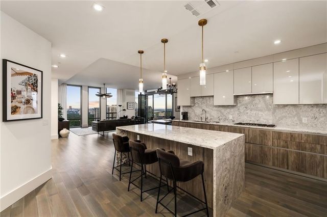 a large kitchen with kitchen island a dining table chairs and a wooden floor