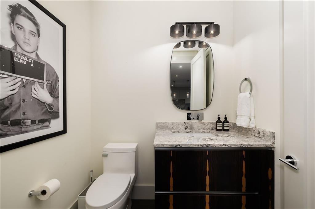 3107 Peachtree Road Northeast, Unit 1803 Atlanta, GA 30305 - Photo 18 of 45 a bathroom with a toilet sink vanity and mirror