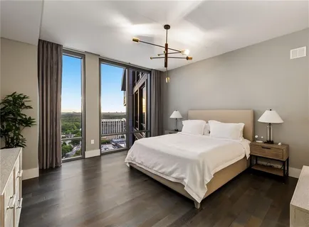 a bedroom with a large bed and a chandelier