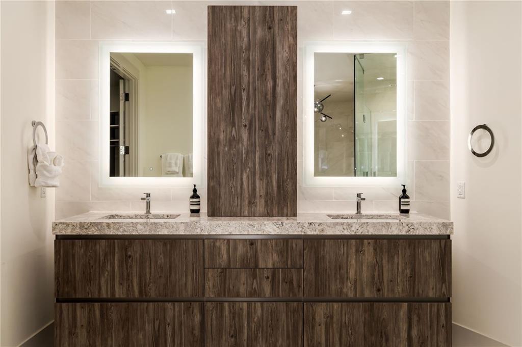 3107 Peachtree Road Northeast, Unit 1803 Atlanta, GA 30305 - Photo 24 of 45 a bathroom with a granite countertop sink and a mirror