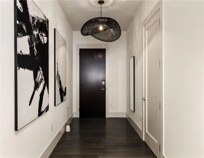a view of a hallway with wooden floor and entryway