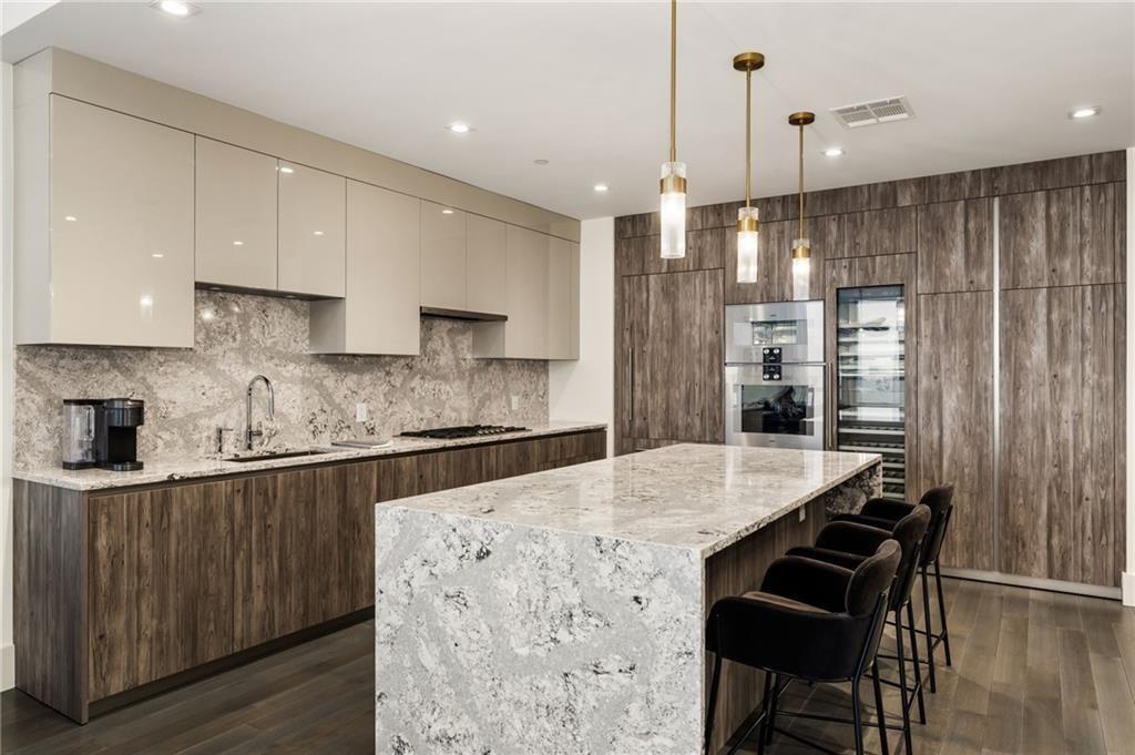 3107 Peachtree Road Northeast, Unit 1803 Atlanta, GA 30305 - Photo 6 of 45 a kitchen with stainless steel appliances kitchen island granite countertop a table chairs in it and wooden floors