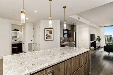 a view of a kitchen with kitchen island a sink stainless steel appliances and a counter top space