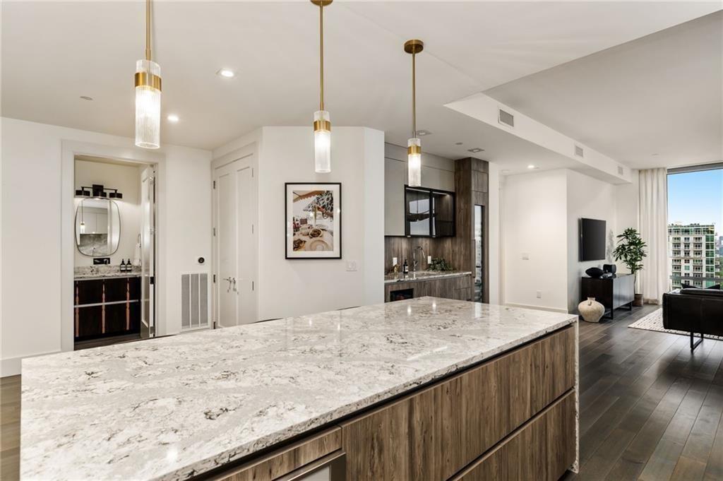 3107 Peachtree Road Northeast, Unit 1803 Atlanta, GA 30305 - Photo 7 of 45 a view of a kitchen with kitchen island a sink stainless steel appliances and a counter top space