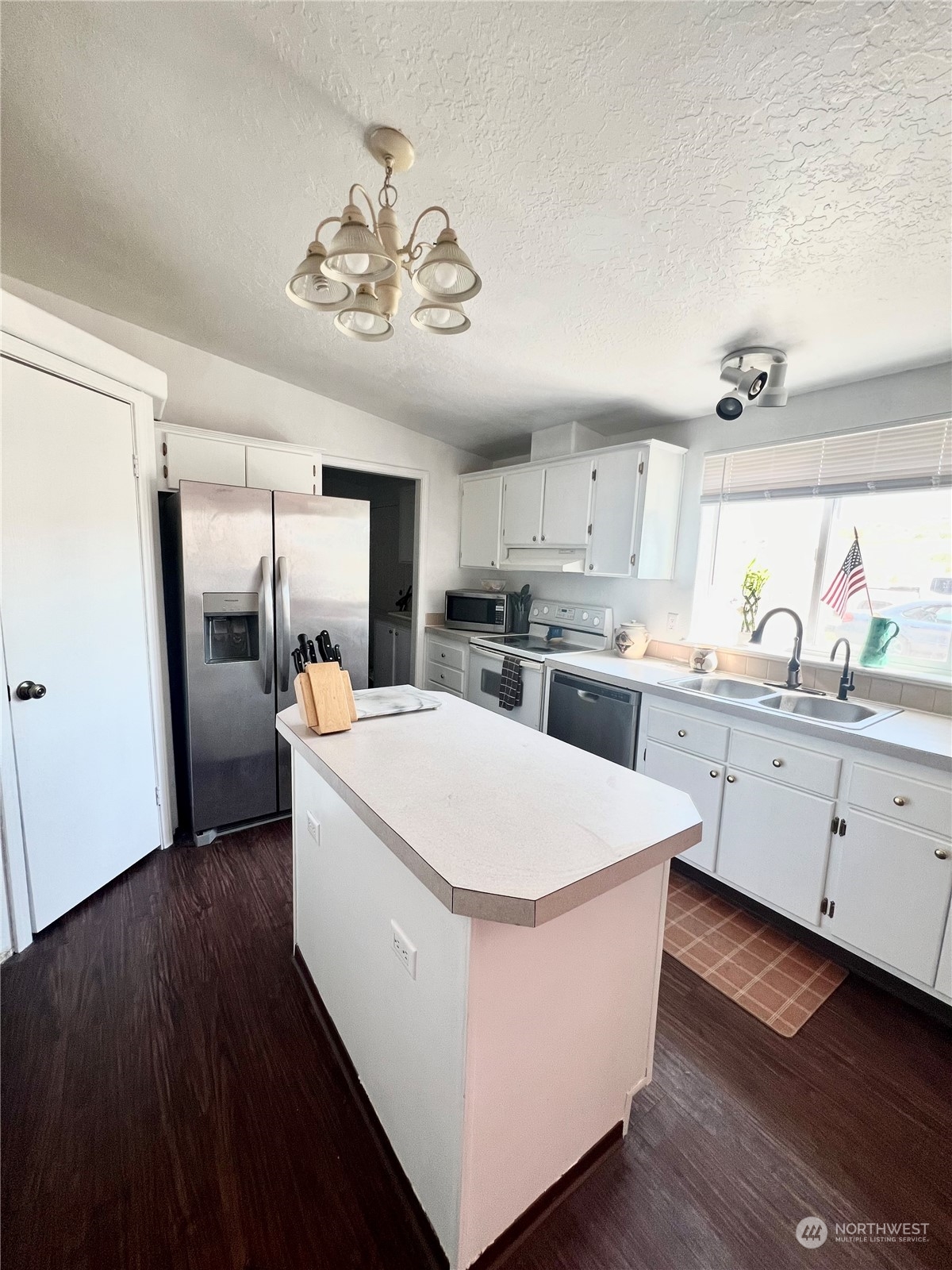 256 C Riverside Cutoff Road Riverside, WA 98849 - Photo 12 of 36 a large white kitchen with wooden floor and stainless steel appliances