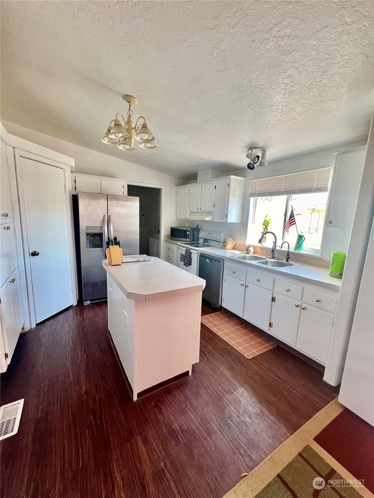 256 C Riverside Cutoff Road Riverside, WA 98849 - Photo 14 of 36 a large white kitchen with a white countertops a stove a dining table and chairs