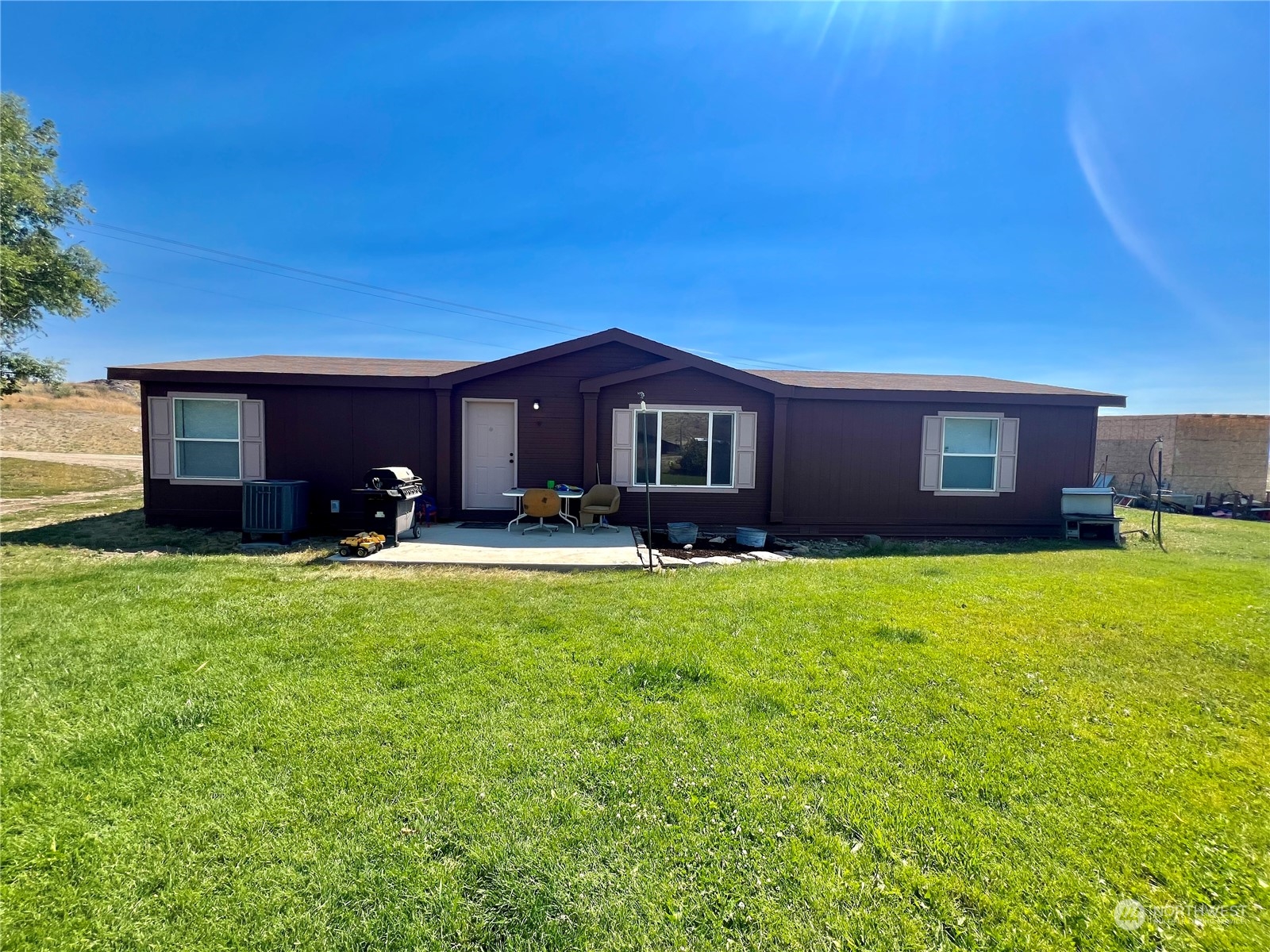 256 C Riverside Cutoff Road Riverside, WA 98849 - Photo 2 of 36 a front view of a house with a garden and plants