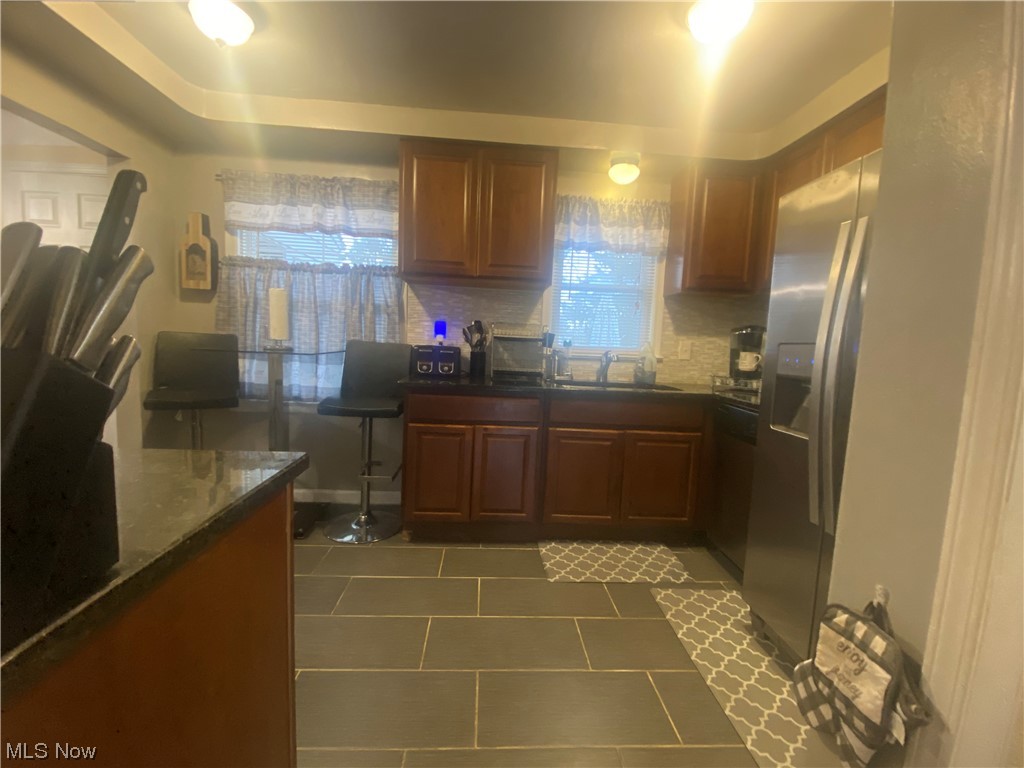 1500 Edgefield Road Lyndhurst, OH 44124 - Photo 6 of 24 Kitchen featuring a wealth of natural light, stainless steel refrigerator with ice dispenser, sink, and backsplash
