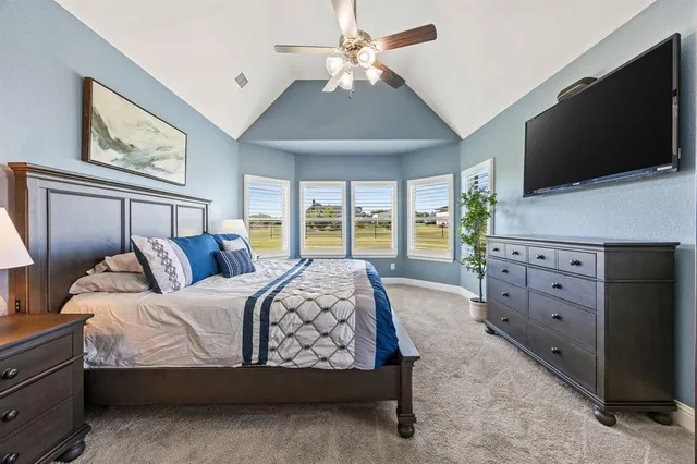 a bedroom with a large bed and a flat screen tv