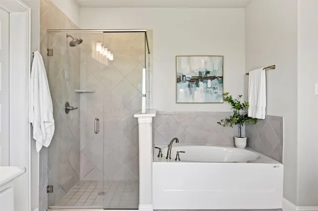 a bathroom with a tub shower and a mirror