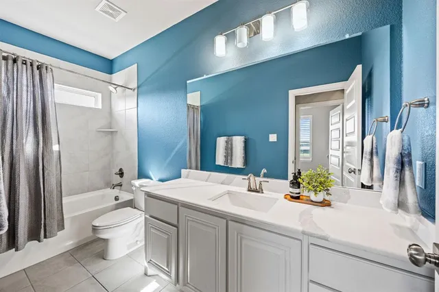 a bathroom with a double vanity sink toilet and shower