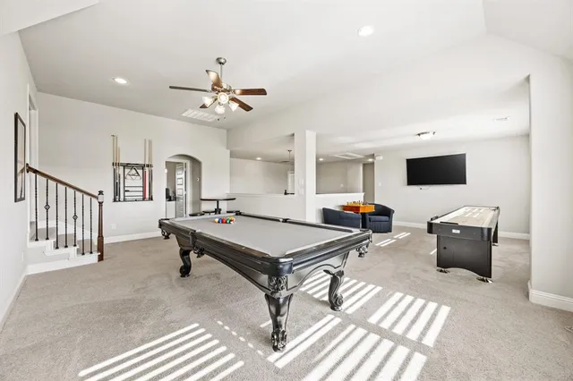 a living room with furniture a flat screen tv and a chandelier