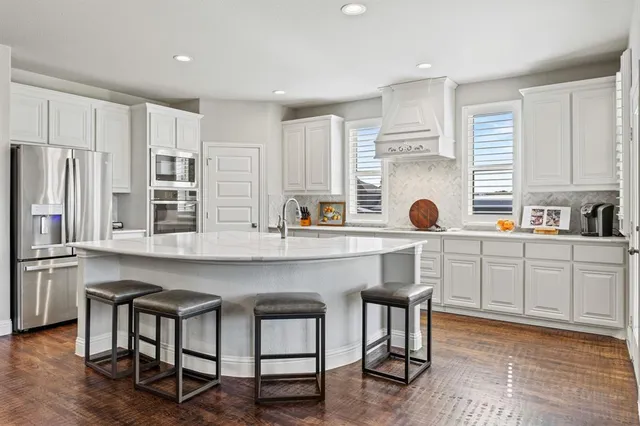 a kitchen with a sink a refrigerator and cabinets