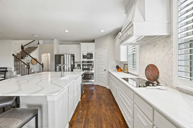 a large kitchen with kitchen island a sink a counter space and appliances