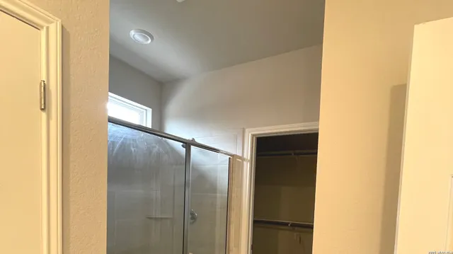 a bathroom with a glass door shower and a sink